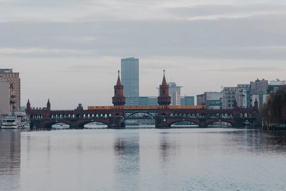 Ein ruhiger Blick auf die Oberbaumbrücke in Berlin, die sich im stillen Wasser der Spree spiegelt, mit der städtischen Skyline im Hintergrund.